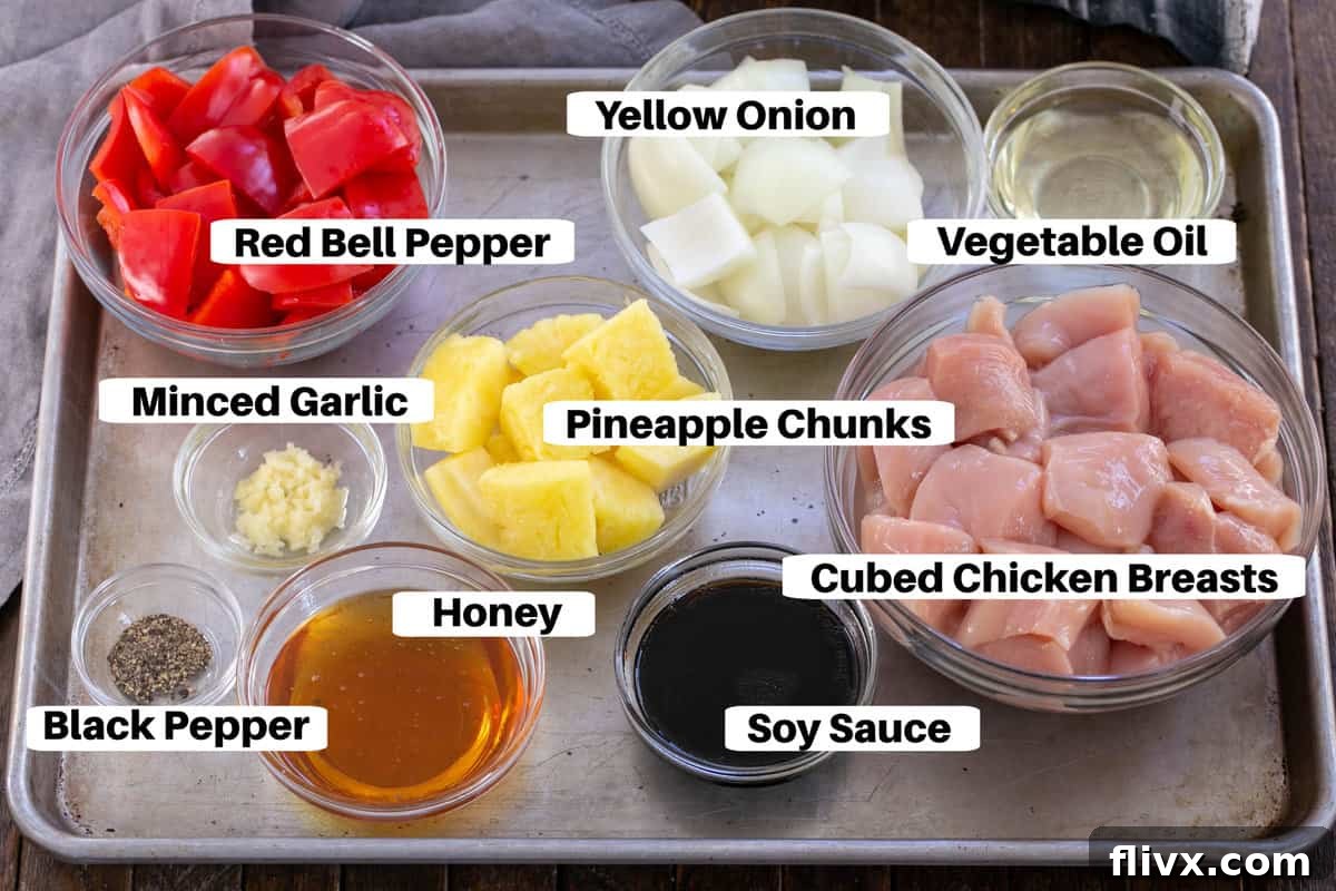 Fresh ingredients for chicken kabobs laid out on a metal sheet pan, labeled for clarity.