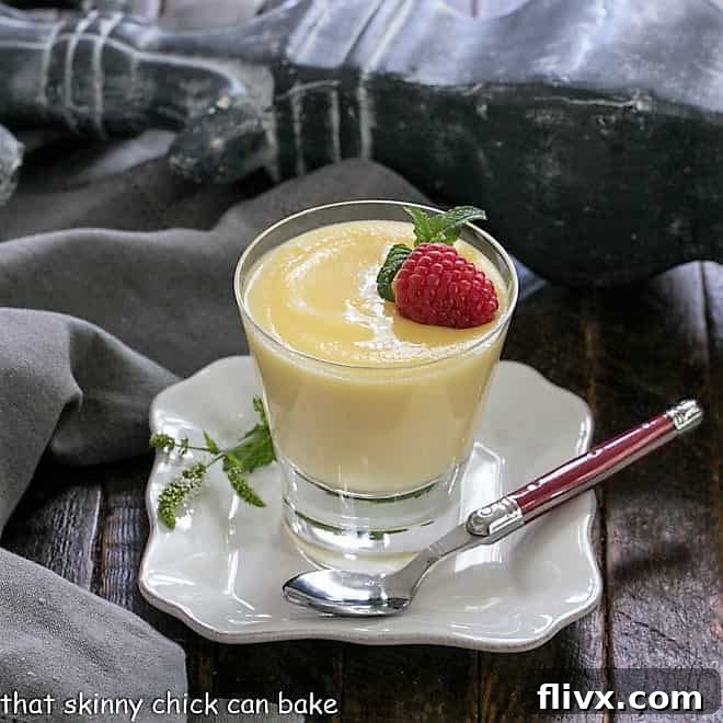 A bowl of creamy White Chocolate Pudding topped with a dollop of whipped cream and chocolate shavings.