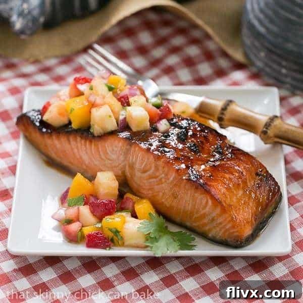 Maple glazed salmon fillet, beautifully cooked and flaky, garnished with fresh herbs.