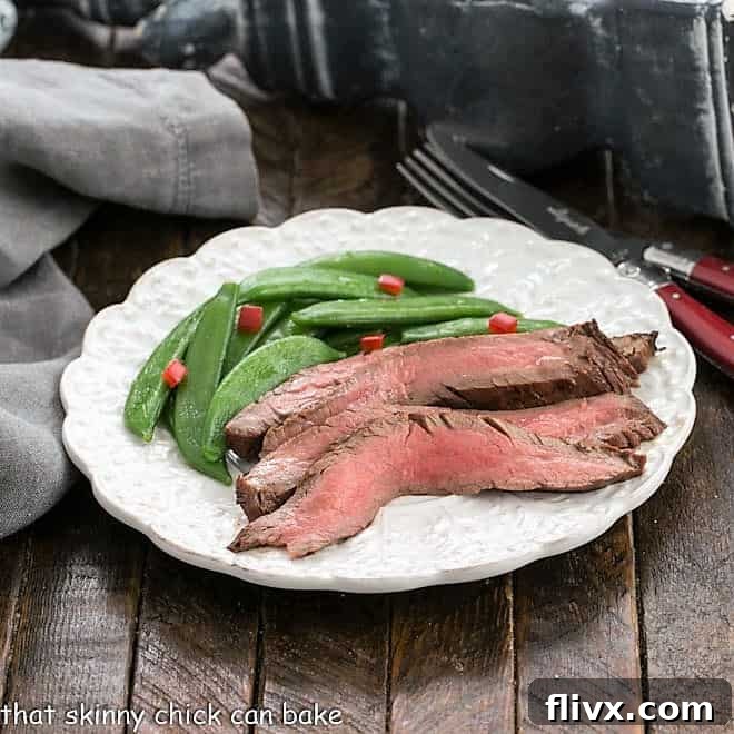 Sliced Korean grilled flank steak, garnished with sesame seeds and green onions.