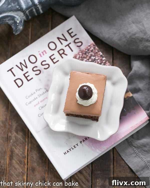A close-up of French Silk Pie Brownies placed elegantly on a plate, resting beside the 'Two in One Desserts' cookbook, highlighting its inspiration.