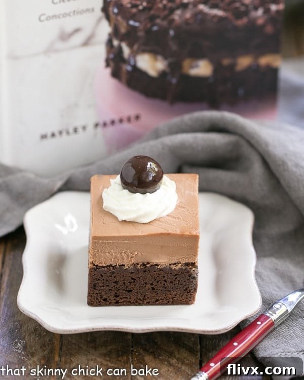 A tempting French Silk Pie Brownie on a white ceramic plate, with a red-handled fork positioned for the first delicious bite.