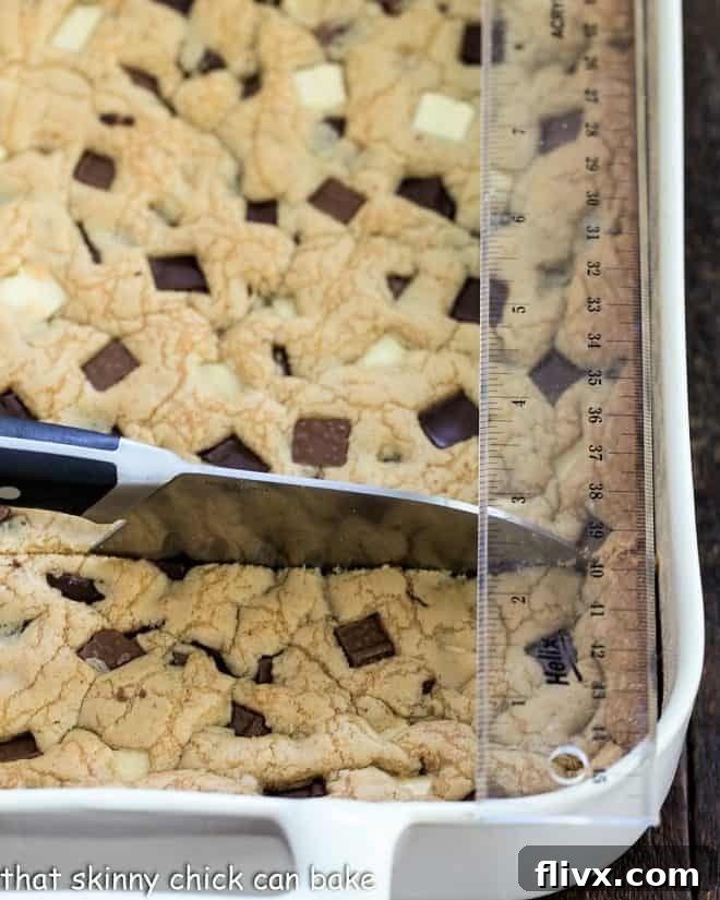 Bar cookies laid out on a cutting board with a knife and ruler, poised for precision cutting