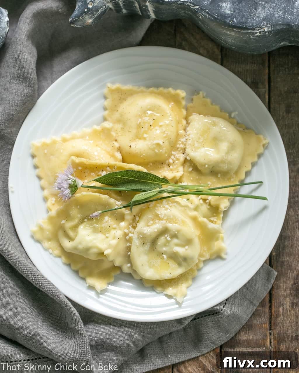 A top-down view of Mozzarella, Basil, Parmigiano-Reggiano Ravioli with Butter Sage Sauce served elegantly on a white dinner plate.