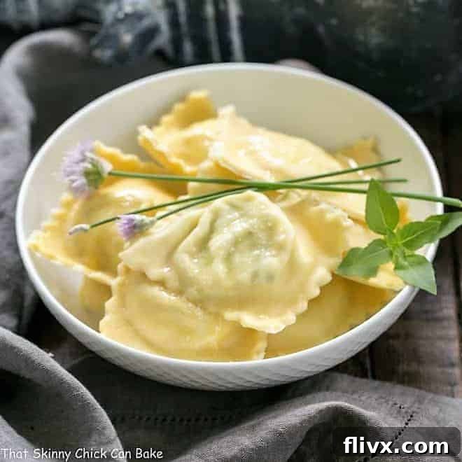 A rustic bowl of Mozzarella, Basil, Parmigiano-Reggiano Ravioli with Butter Sage Sauce, garnished generously with fresh basil leaves and delicate chives.