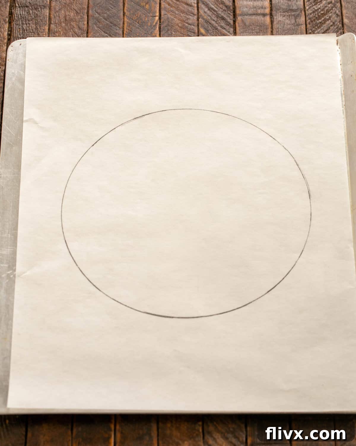 Parchment paper marked with a 9-inch circle, ready for the pavlova meringue on a baking sheet.