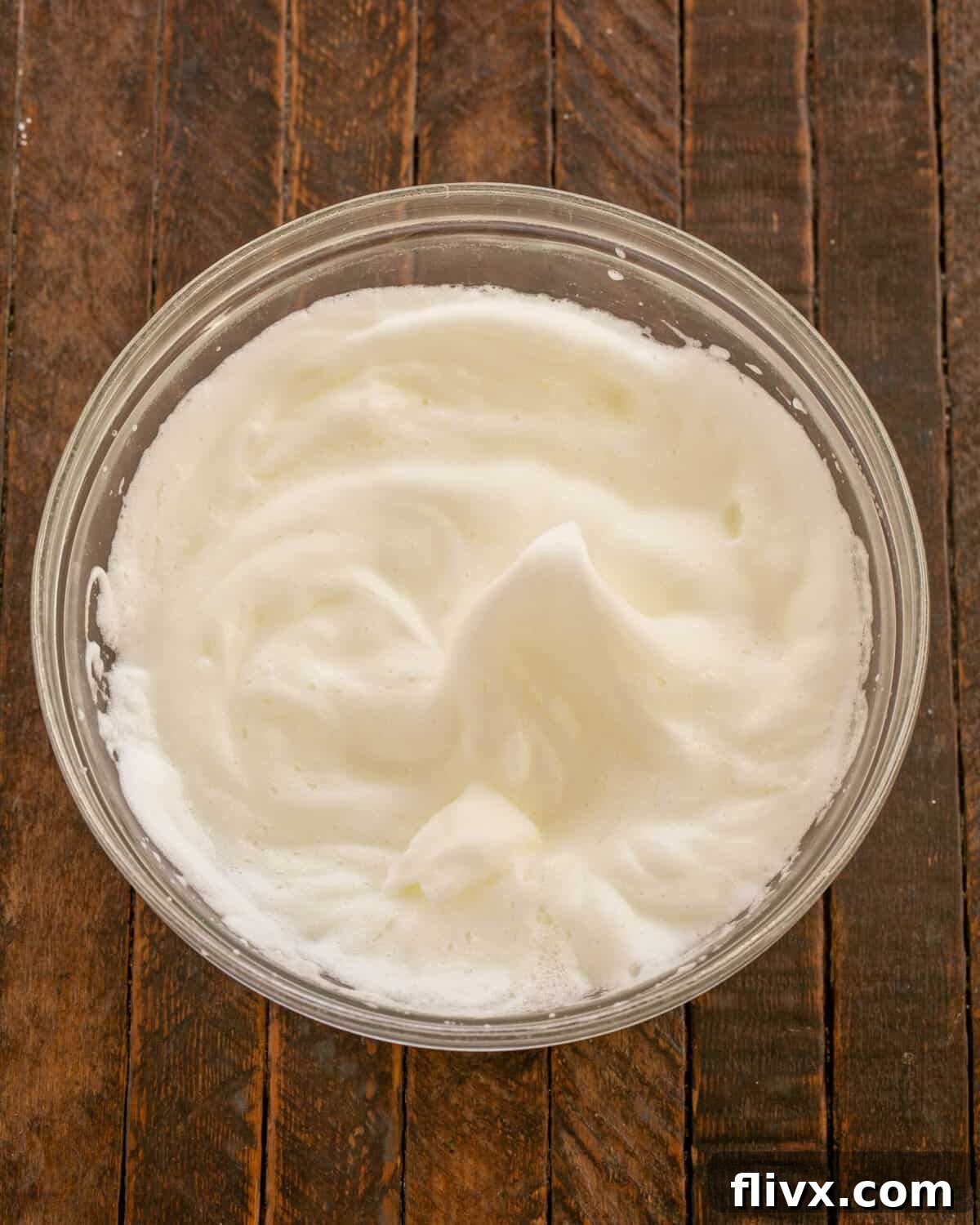 Fluffy, beaten egg whites in a clean mixing bowl.