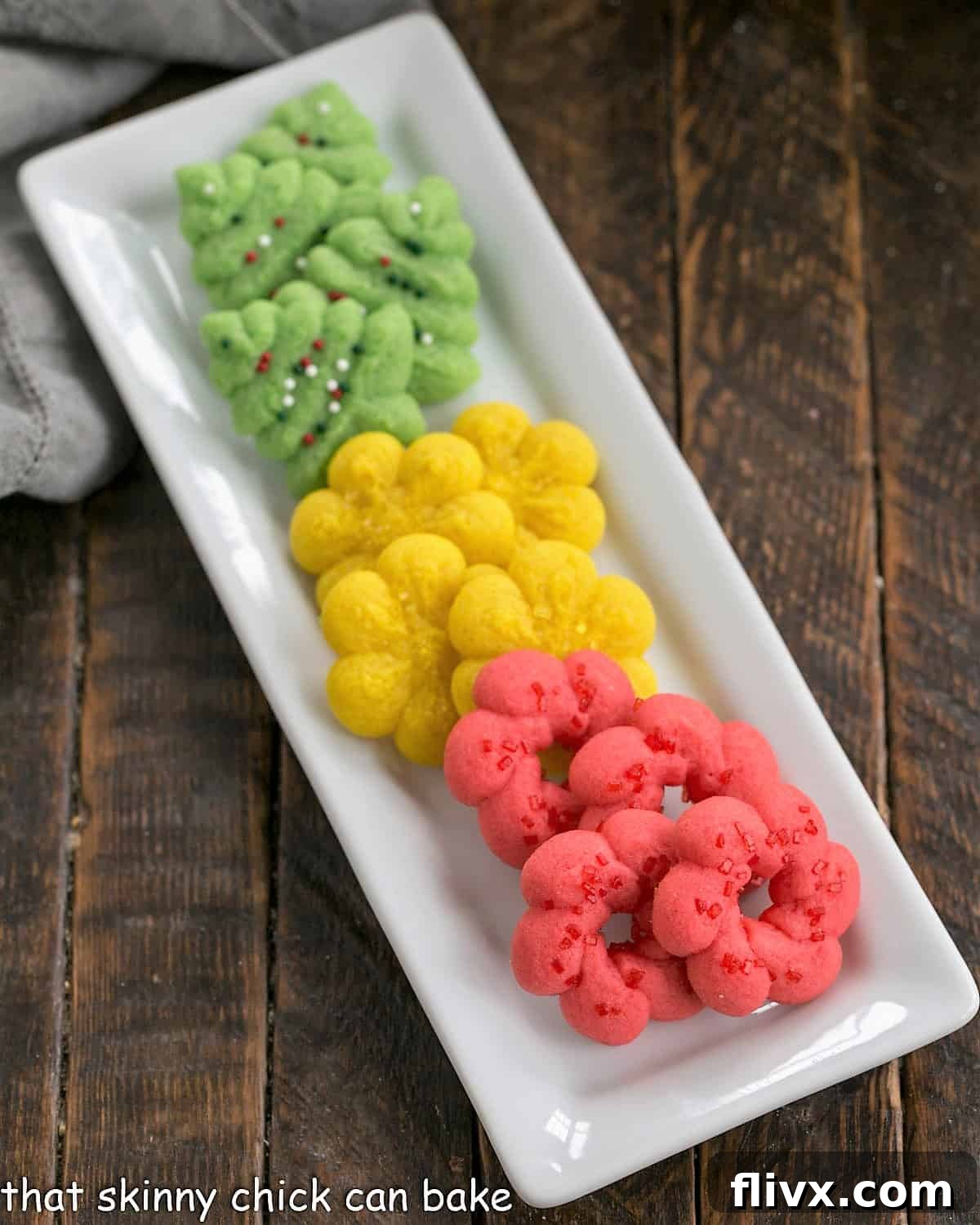 Colorfbuttery spritz cookies on a white ceramic tray.