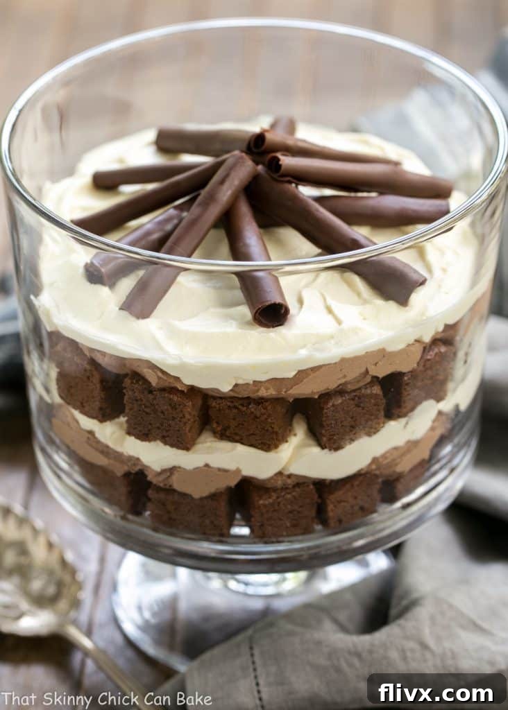 A stunning side view of the Fudgy Brownie Trifle with Chocolate Mousse in a tall glass trifle bowl, highlighting its distinct, creamy layers and brownie chunks.