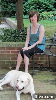 A girl sitting on a bench with a dog