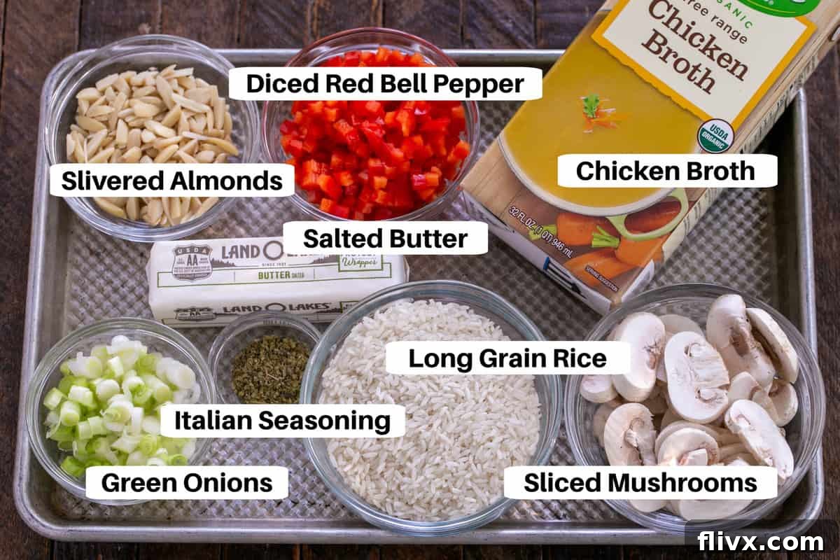 Variety of fresh ingredients for Italian Rice Pilaf, including rice, mushrooms, bell pepper, and seasonings, neatly arranged on a sheet pan.