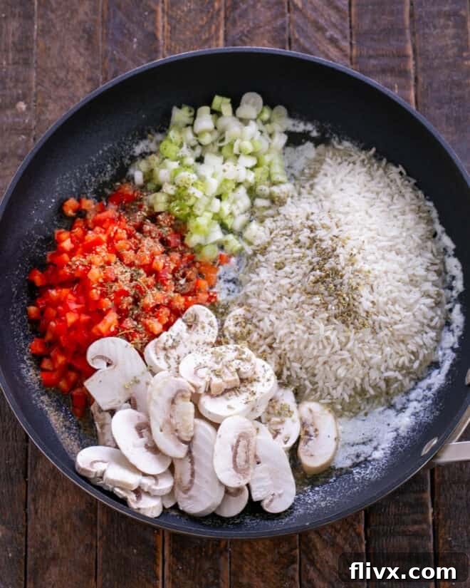 Rice, mushrooms, bell peppers, green onions, and Italian seasoning added to melted butter in a skillet.