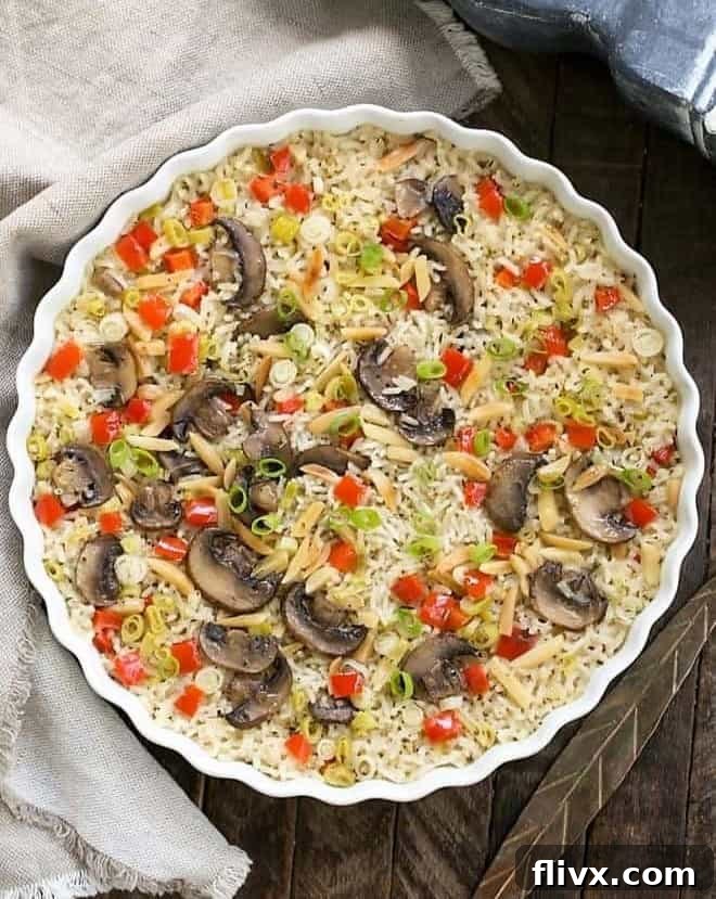 Oven-baked rice pilaf, covered with foil, in a round dish, resting after cooking.
