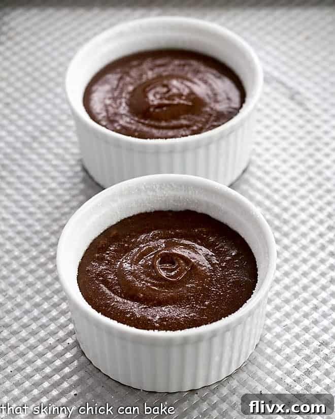 Rich, glossy chocolate lava cake batter meticulously poured into prepared ramekins, awaiting their transformation in the oven.