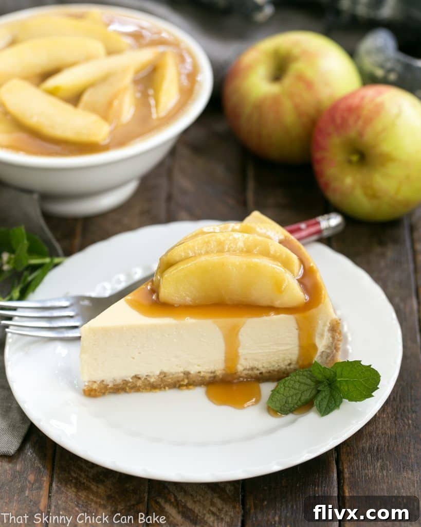 A delectable slice of Easy Sour Cream Cheesecake with Caramel Apples on a pristine white dessert plate, adorned with a drizzle of caramel sauce and apple chunks.