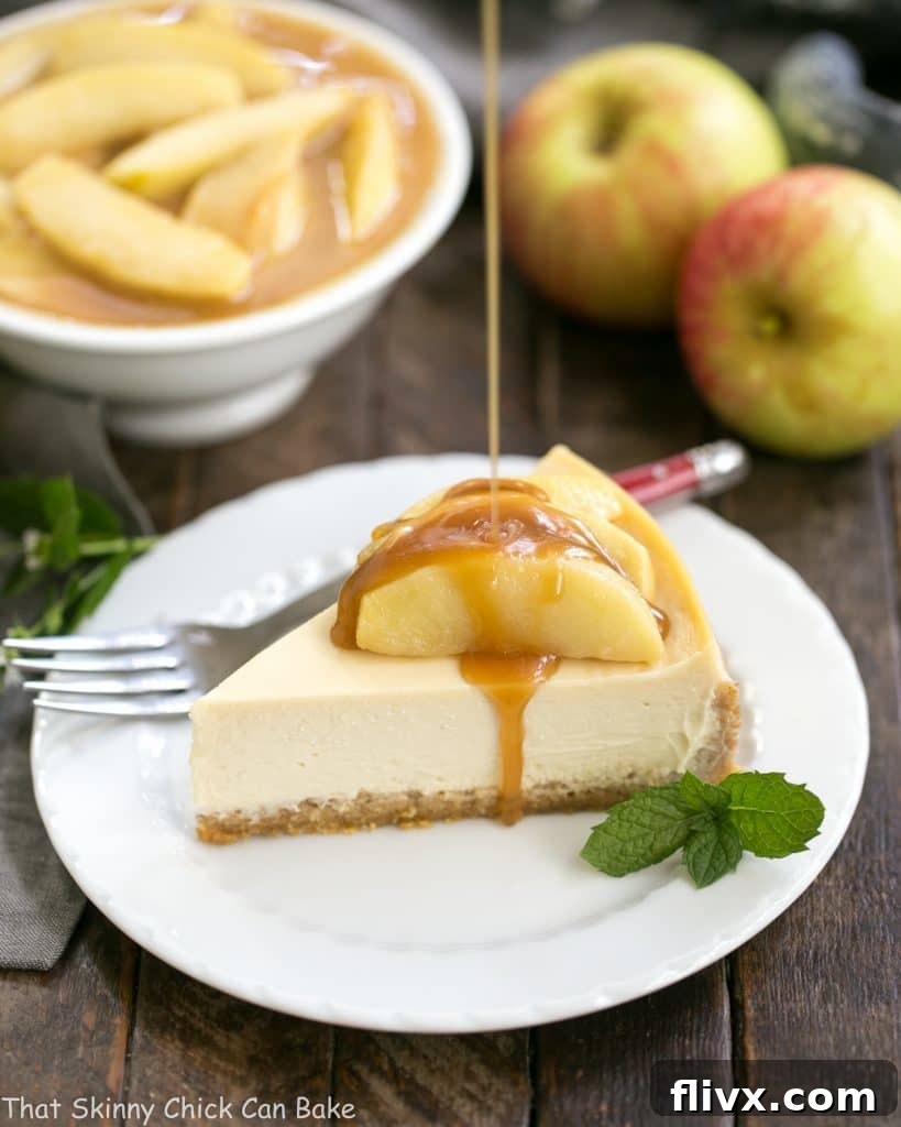 A mesmerizing shot of warm caramel sauce artfully pouring over a freshly cut slice of Easy Sour Cream Cheesecake with Caramel Apples, ready to be savored.