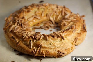 Close-up shot of a perfectly baked golden-brown choux pastry ring, the base for Paris-Brest