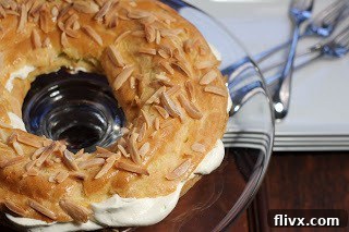 A close-up view of a freshly baked Paris-Brest, generously filled with a rich, smooth cream
