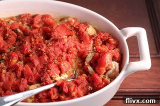 Chicken Feta Casserole presented in a white casserole dish with a serving spoon, showcasing its hearty texture.