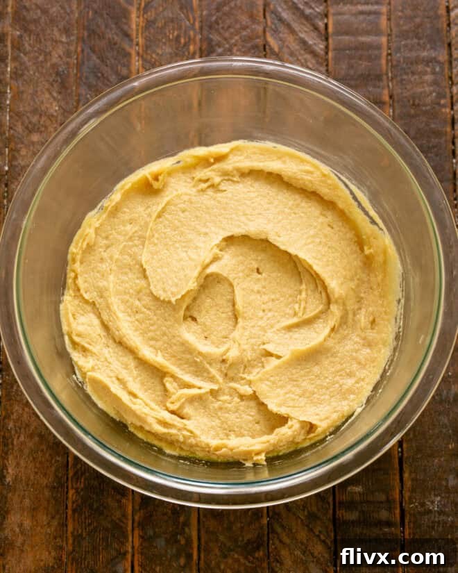 Eggs being mixed into the creamed butter and sugar mixture.