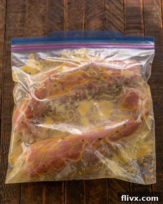 Pork tenderloins being placed into a Ziploc bag with the maple and mustard marinade.