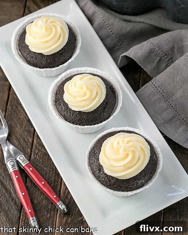Frosted Black Bottom Cupcakes elegantly arranged on a pristine white tray, showcasing their fluffy frosting and chocolate base.