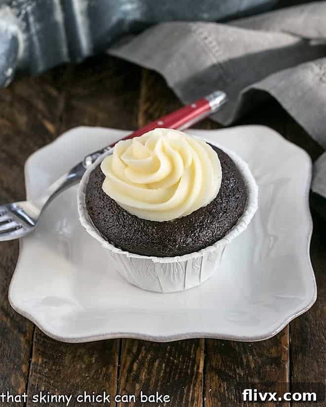 A beautifully presented black bottom cupcake on a square white plate, ready to be enjoyed.