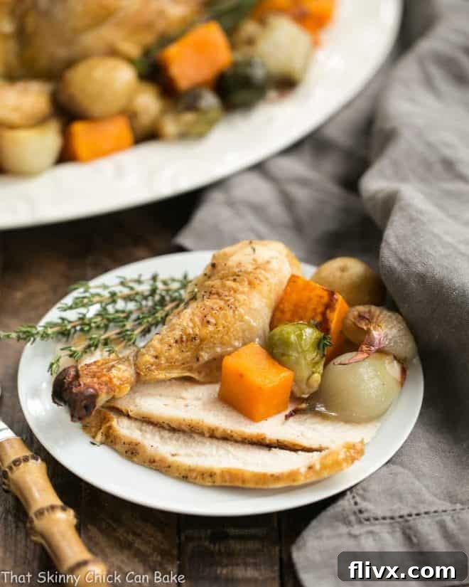 Golden brown sheet pan chicken with roasted butternut squash, Brussels sprouts, and new potatoes on a serving platter, with a single serving on a white plate.