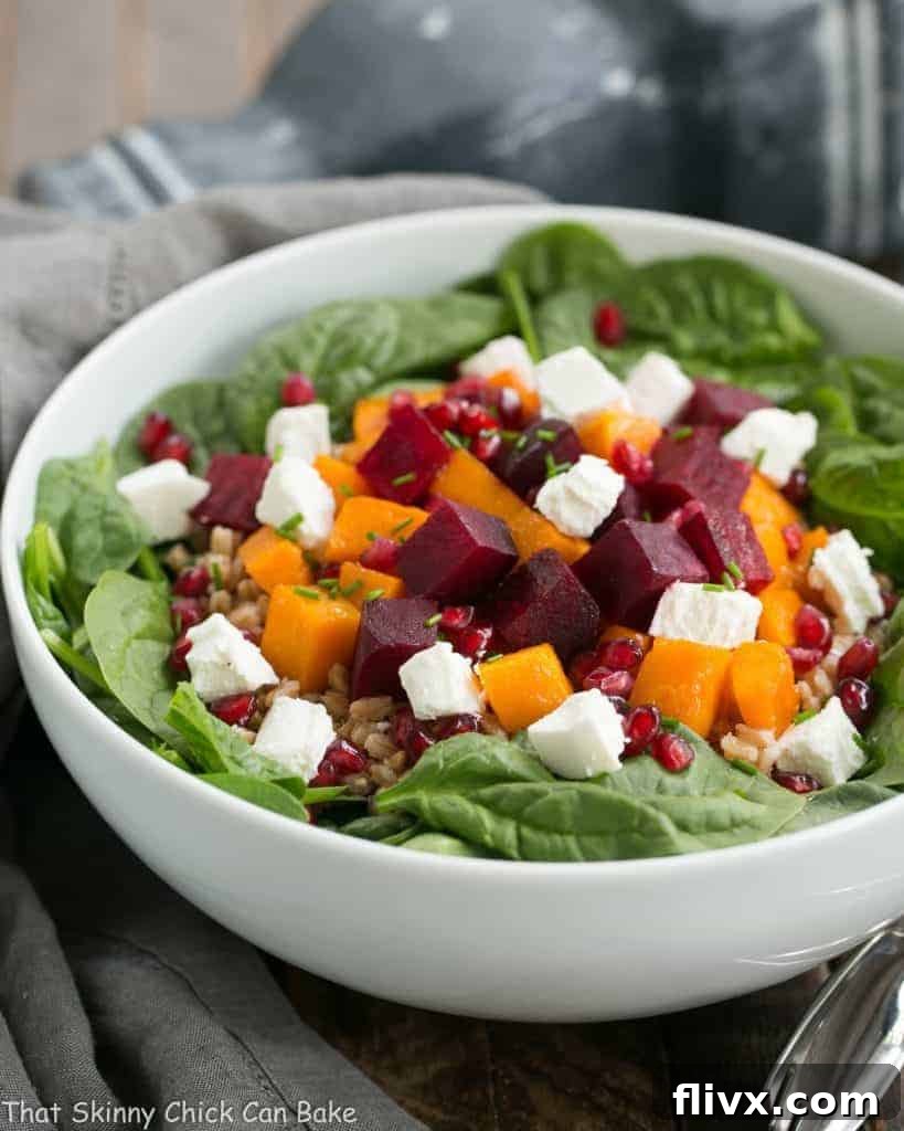 A vibrant Roasted Fall Vegetable Salad featuring roasted beets and butternut squash, mingled with farro, fresh spinach, and creamy goat cheese. The perfect autumnal dish.