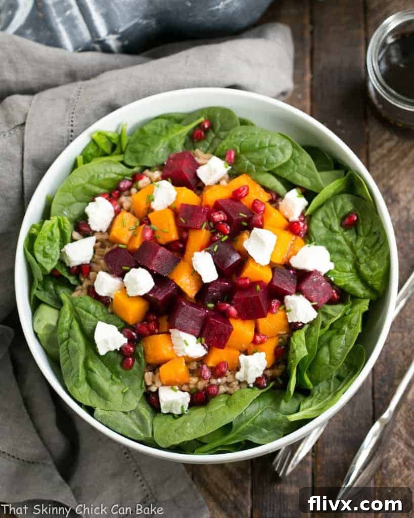 The finished Roasted Fall Vegetable Salad, ready to be served, highlighting the beautiful textures and colors of roasted beets, butternut squash, farro, and fresh spinach. Drizzled with maple balsamic vinaigrette.