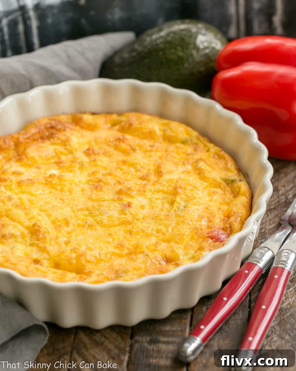 A wide shot of a baked Denver omelet resting in a white porcelain baking dish, boasting a golden-brown top and an inviting texture.