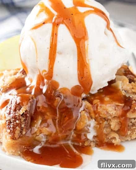 Caramel Apple Pie Bars topped with a cinnamon pecan streusel, served warm with ice cream and caramel drizzle.