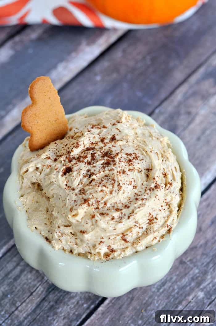 A festive Four Ingredient Pumpkin Pie Dip served in a bowl with various dippers like graham crackers and apple slices.