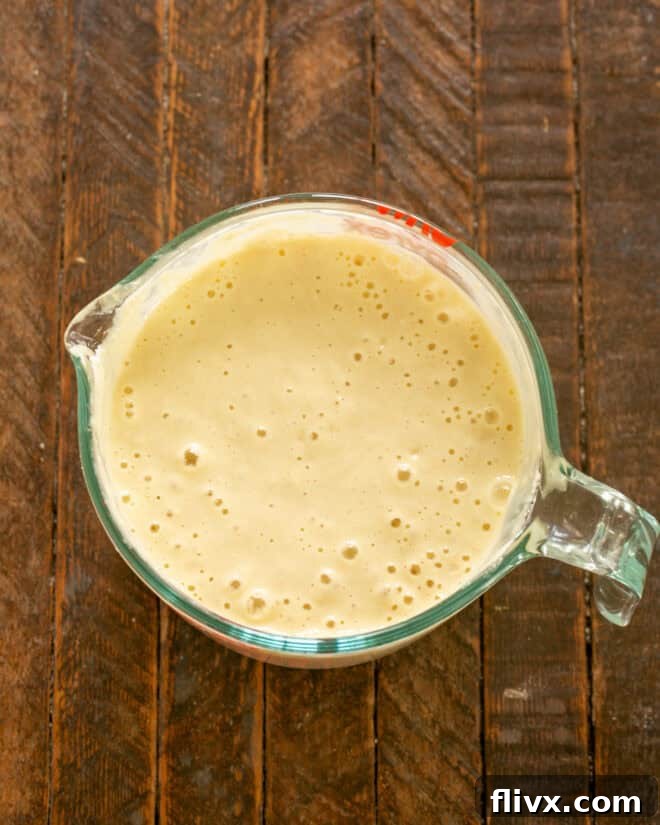 Mixing dry ingredients into wet ingredients for pancake batter.