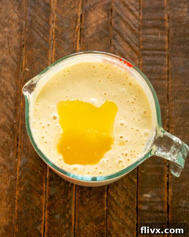 Stirring melted butter into pancake batter.