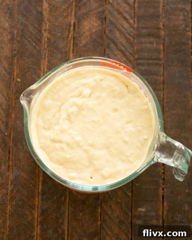 Pouring pancake batter onto a hot griddle.