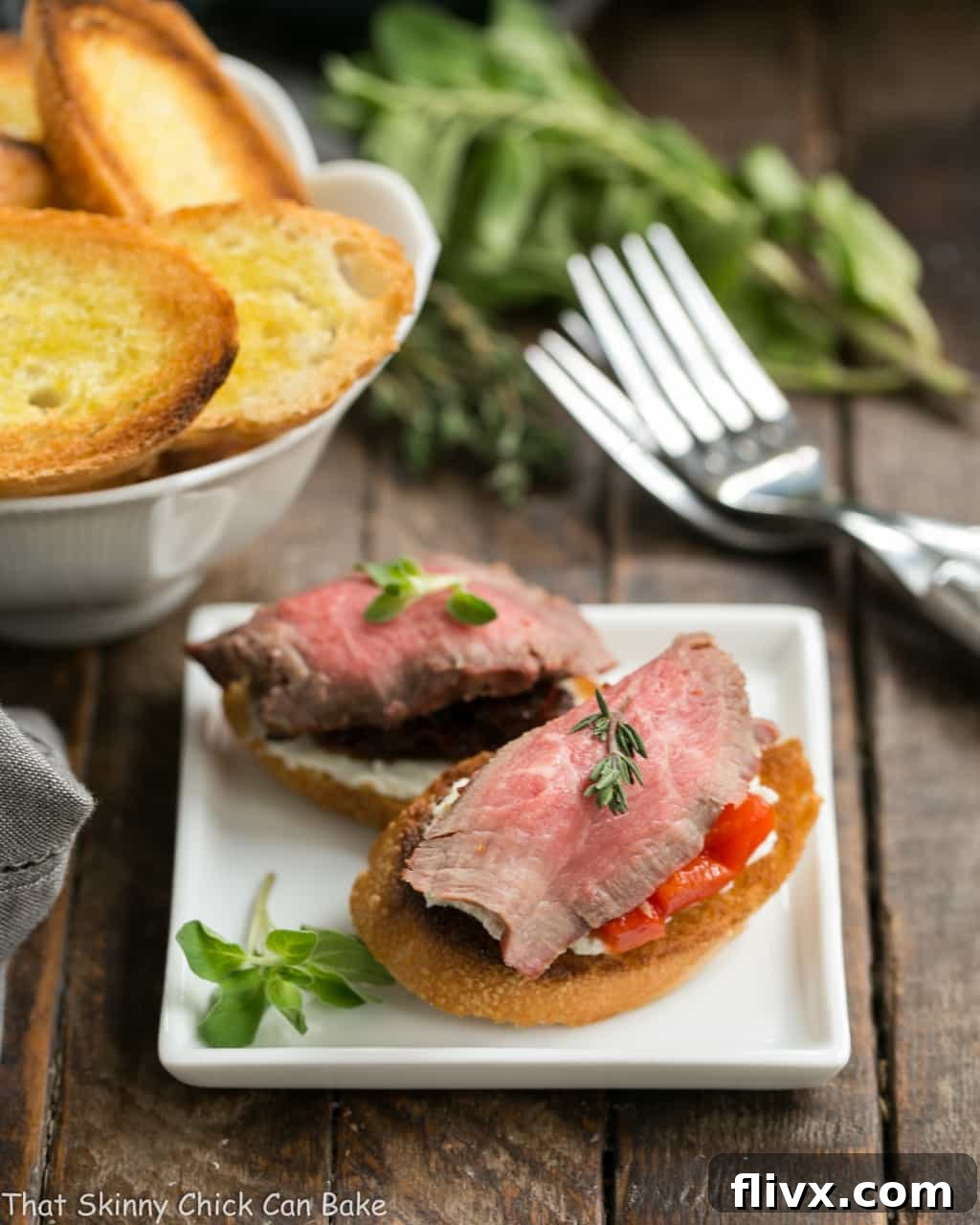 Elegant Beef Crostini with Blue Cheese on a square white appetizer plate, perfectly garnished and ready to serve.