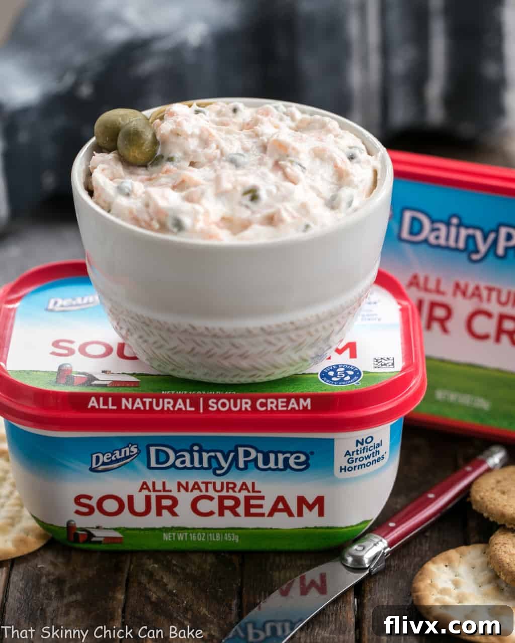 A bowl of Smoked Salmon Dip with Capers artfully placed on a container of DairyPure sour cream.