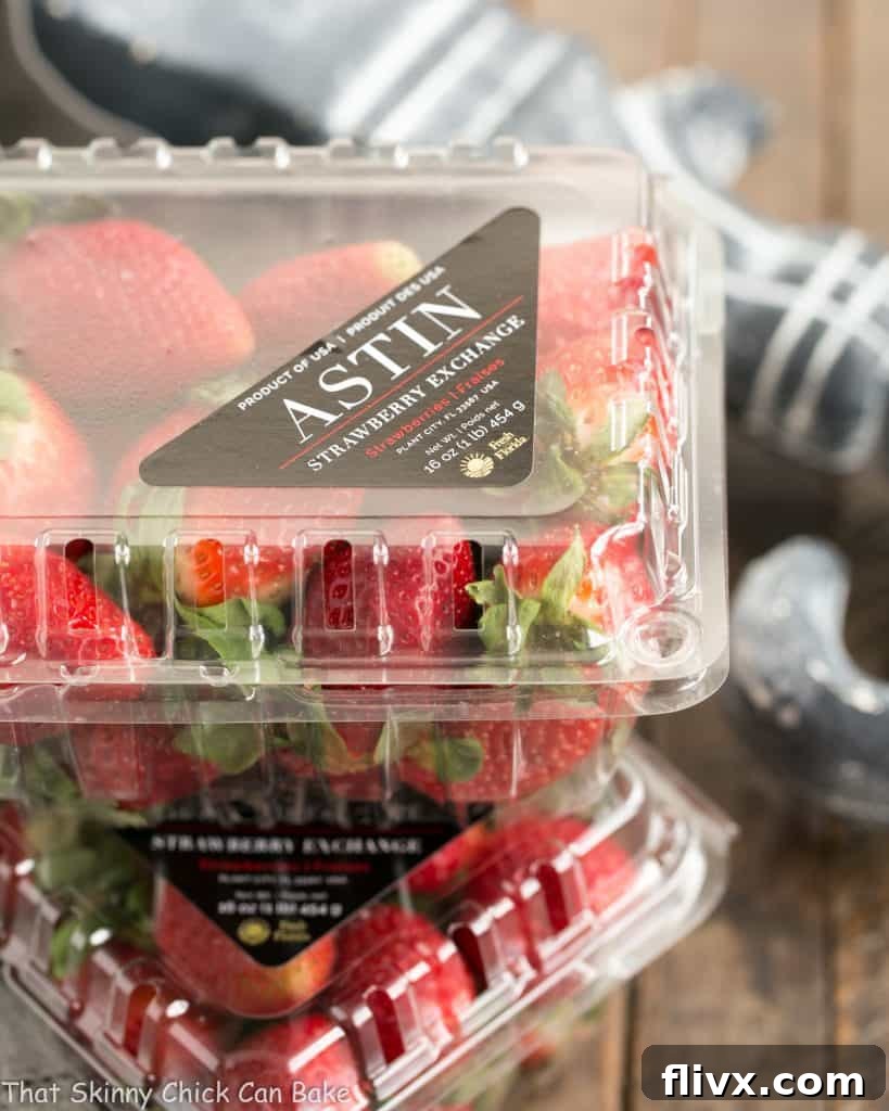 Two vibrant red boxes of fresh, ripe strawberries, overflowing with berries, showcasing their natural beauty.