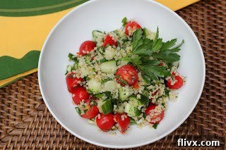 Overhead view of tabbouleh recipe in a white bowl garnished with parsley