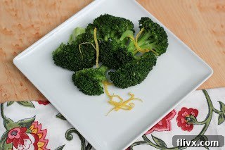 Close-up of vibrant green broccoli florets steaming in a metal pot, cooking to perfection.