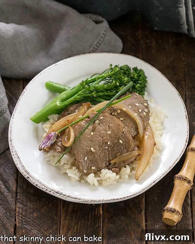 Overhead view of Pork Bulgogi arranged attractively on a round white plate, garnished with sesame seeds.