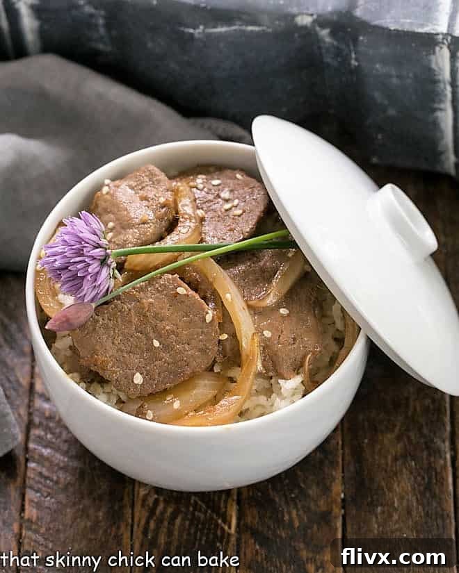 Pork Bulgogi in a white bowl over rice, garnished with chives.