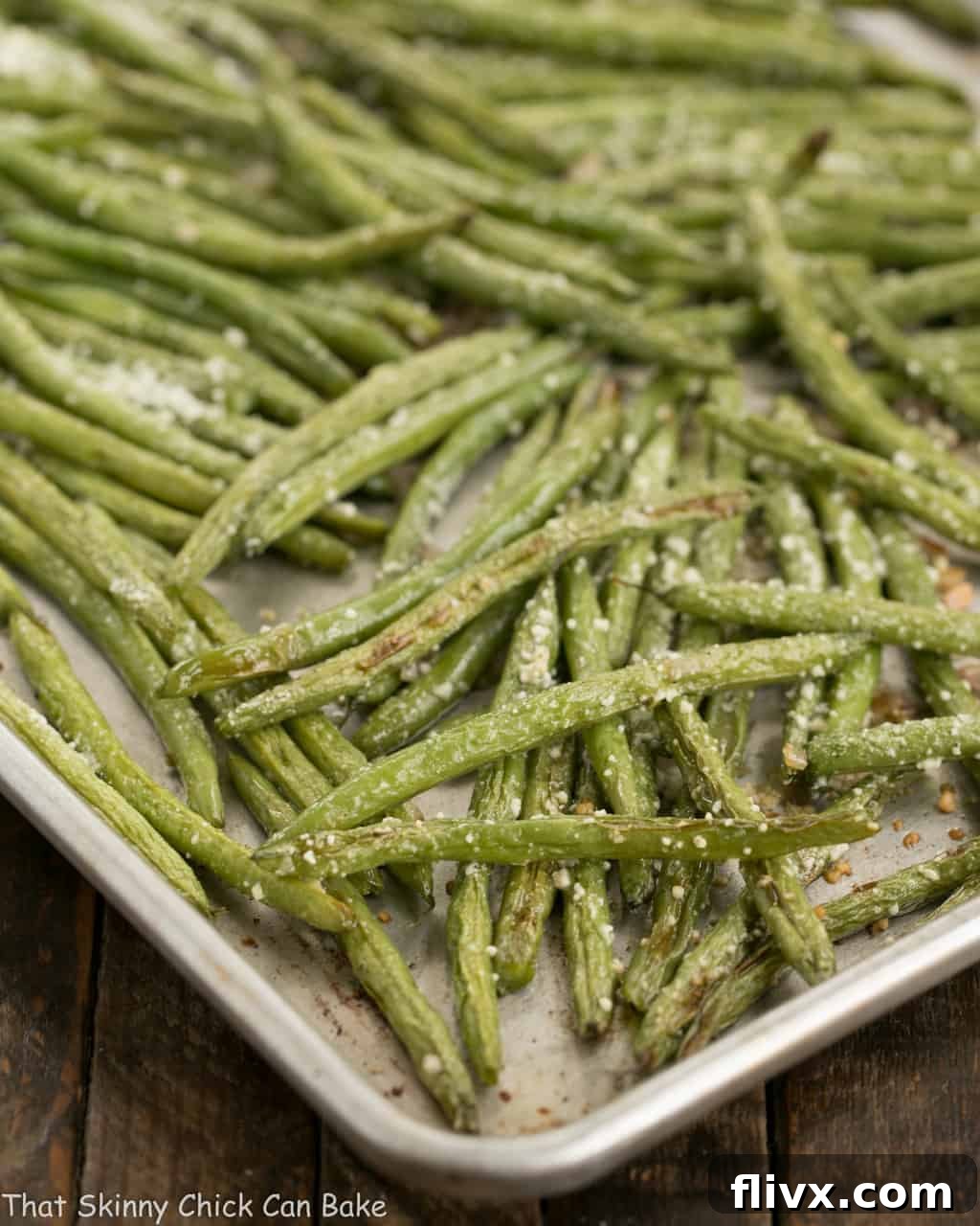 Garlic Parmesan Roasted Green Beans spread out on a sheet pan, ready for roasting.