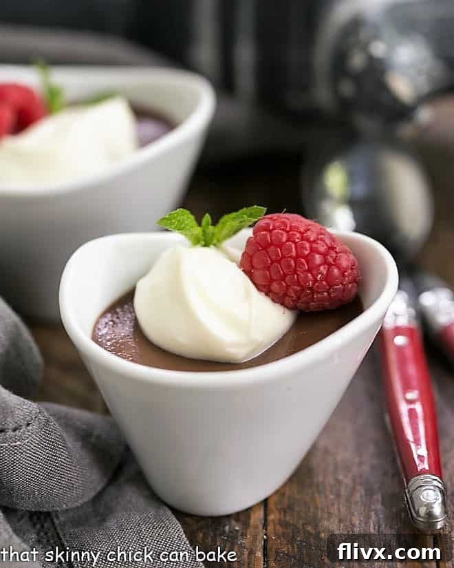 Chocolate Pots de Creme topped with white chocolate cream and raspberries.