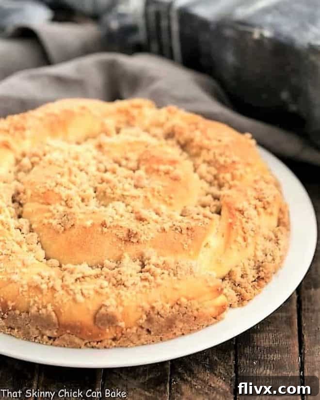 Copycat Sara Lee Coffee Cake on a white serving plate, showcasing its golden-brown crust and intricate twists.