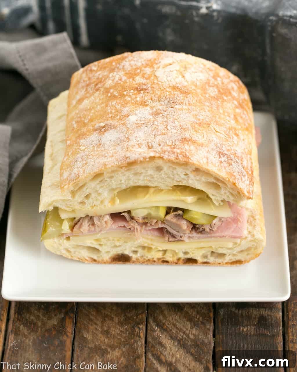 Side view of Ciabatta Cubano Sandwich Recipe before cooking, showcasing the layers of meat, cheese, and pickles.