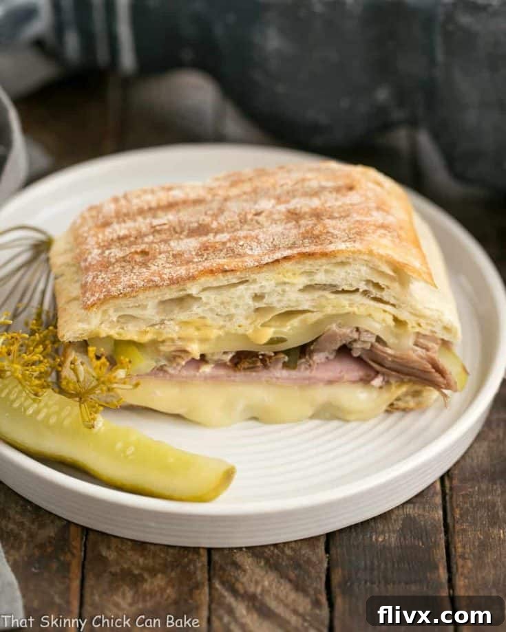 A perfectly pressed Ciabatta Cubano Sandwich, cut in half to show the layered ingredients.