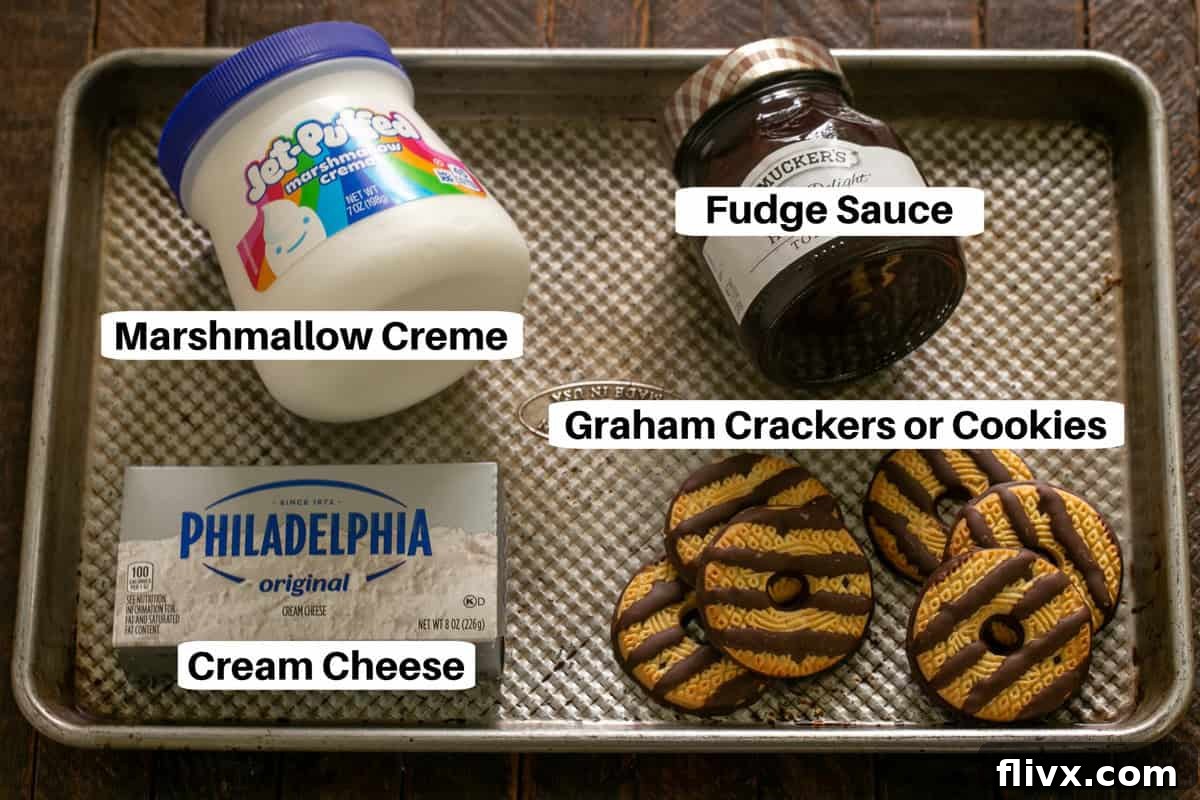 A neatly arranged flat lay of the three essential ingredients for Easy S'mores Dessert Dip on a sheet pan, clearly labeled for convenience. This includes a block of softened cream cheese, a jar of classic marshmallow creme, and a bottle of rich fudge sauce, all ready to be transformed into a delicious treat.