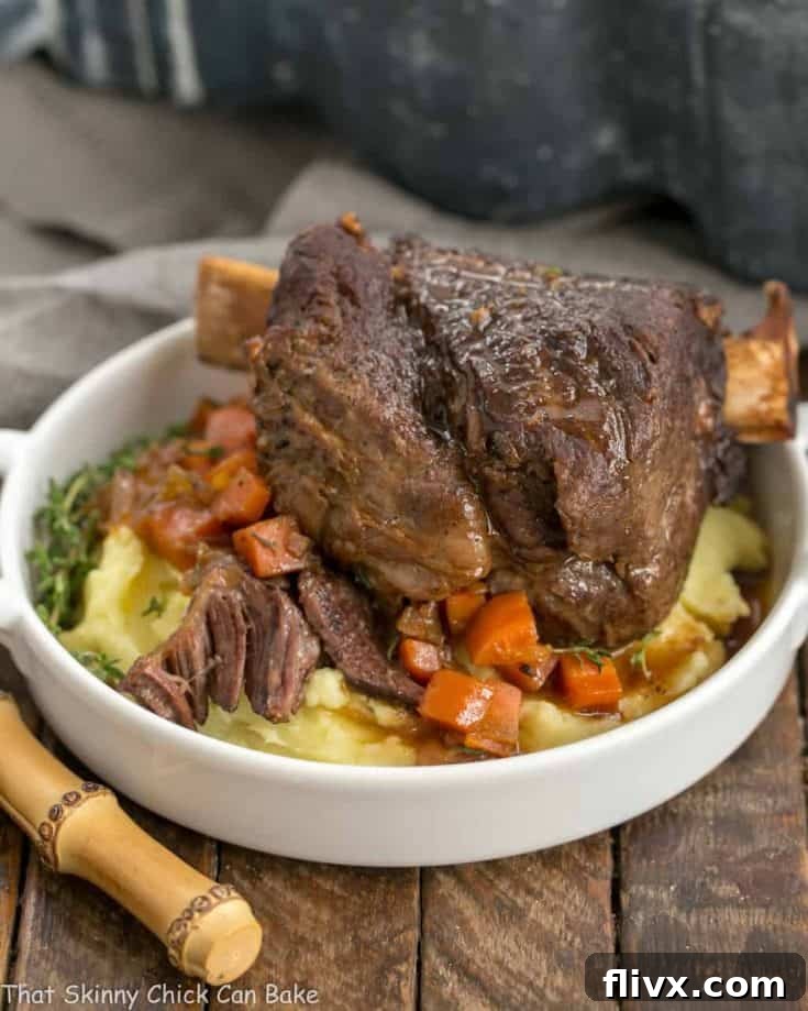 A plate of food, with Beef Short Ribs over potatoes